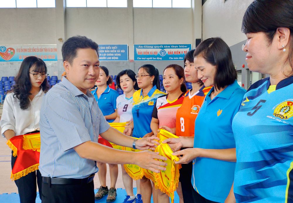 Ông Lâm Thành Sĩ - Chủ tịch LĐLĐ tỉnh An Giang trao cờ lưu niệm cho đại diện các đội tham gia Giải bóng chuyền hơi nữ tỉnh An Giang năm 2023. Ảnh: Lục Tùng